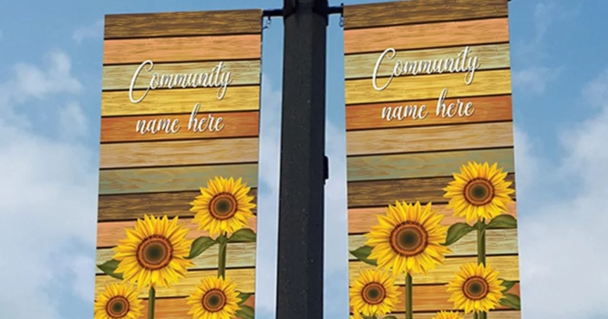 Decorative sunflower community banners on a light post with text reading 